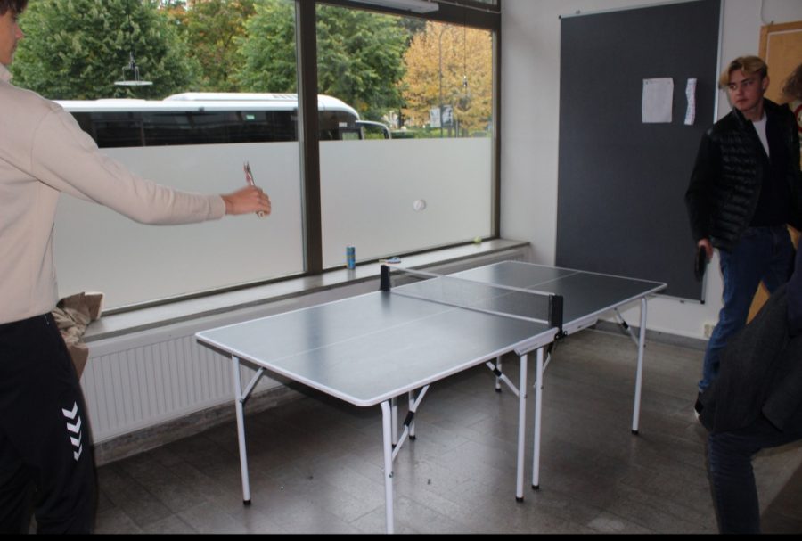 Students playing table tennis.

