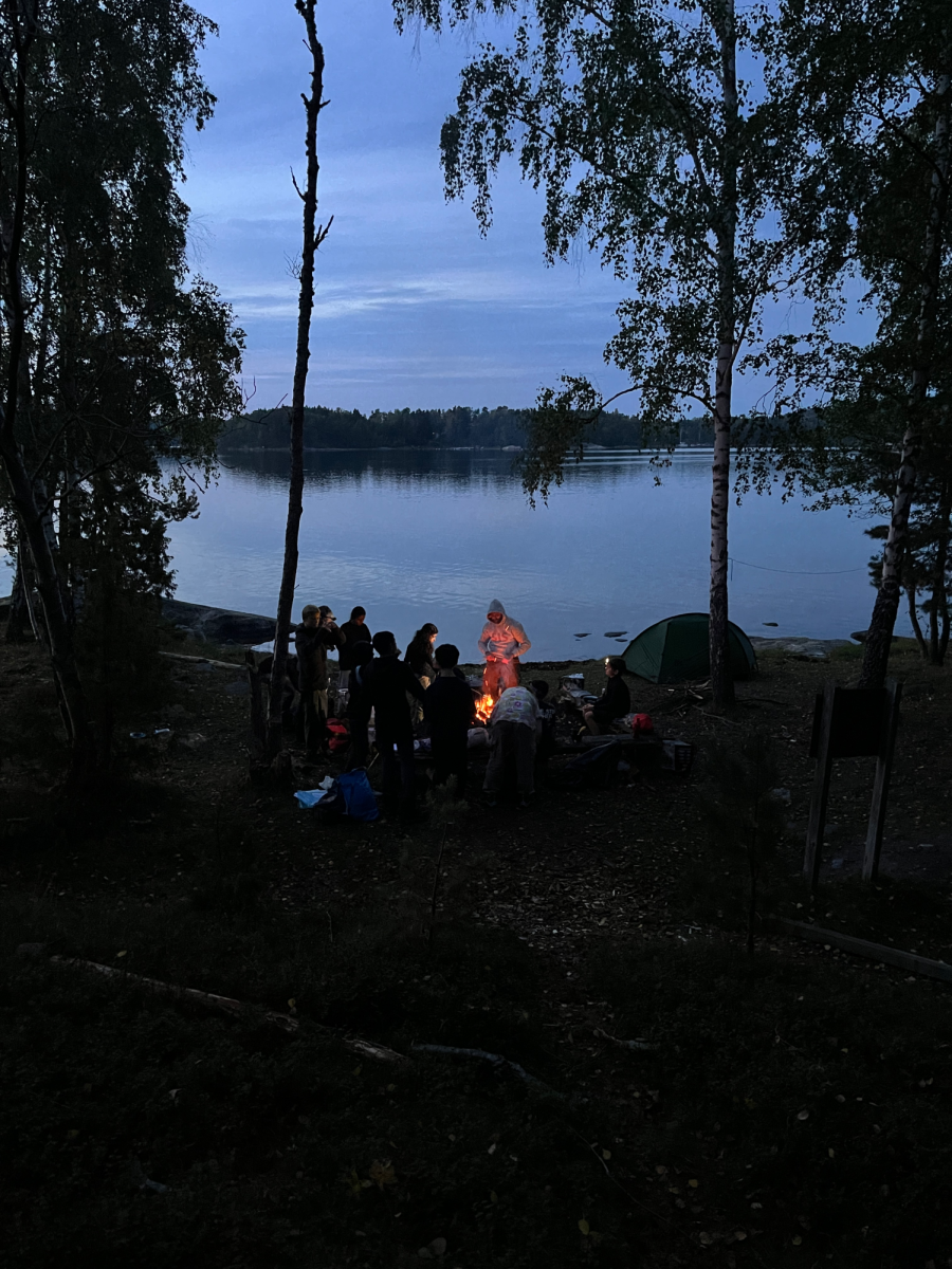 Students gathered around a campfire in the evening 